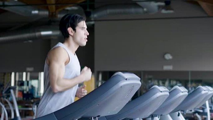 健身房里一个光着膀子的人，训练他的身体保持健康，并有明确的肌肉。运动员举起沉重的重量和乏力。