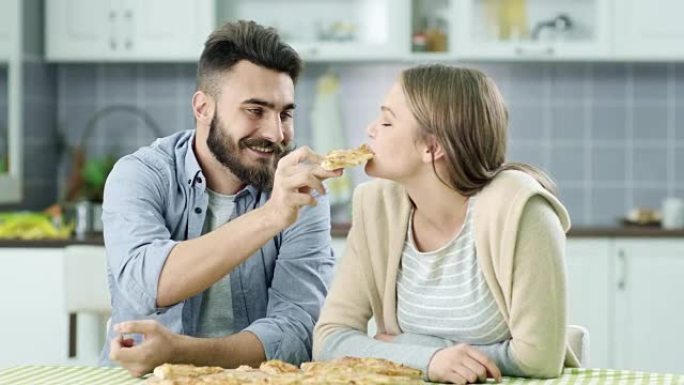 年轻夫妇吃披萨约会同学高兴