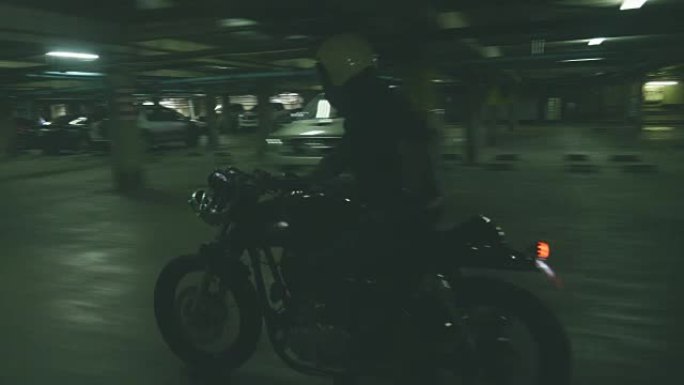 男子在黑暗的停车场驾驶摩托车
