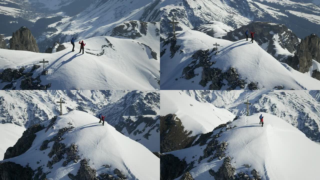 登山者在白雪覆盖的山峰上欢呼雀跃，山峰上有一个十字架