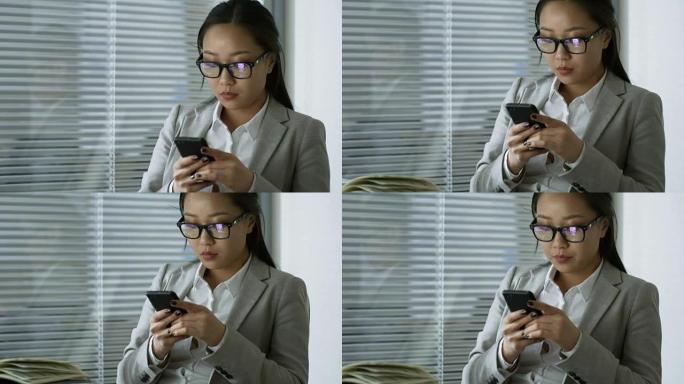 女性员工在工作中使用智能手机