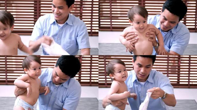 泰国家庭在家亲子关系穿衣服爸爸带小孩