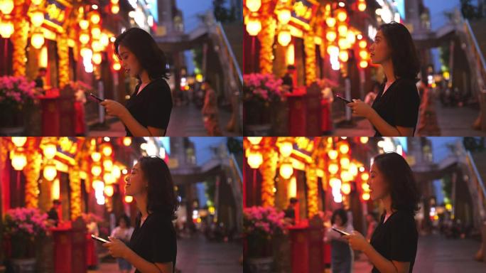 年轻的中国妇女在街上使用电话