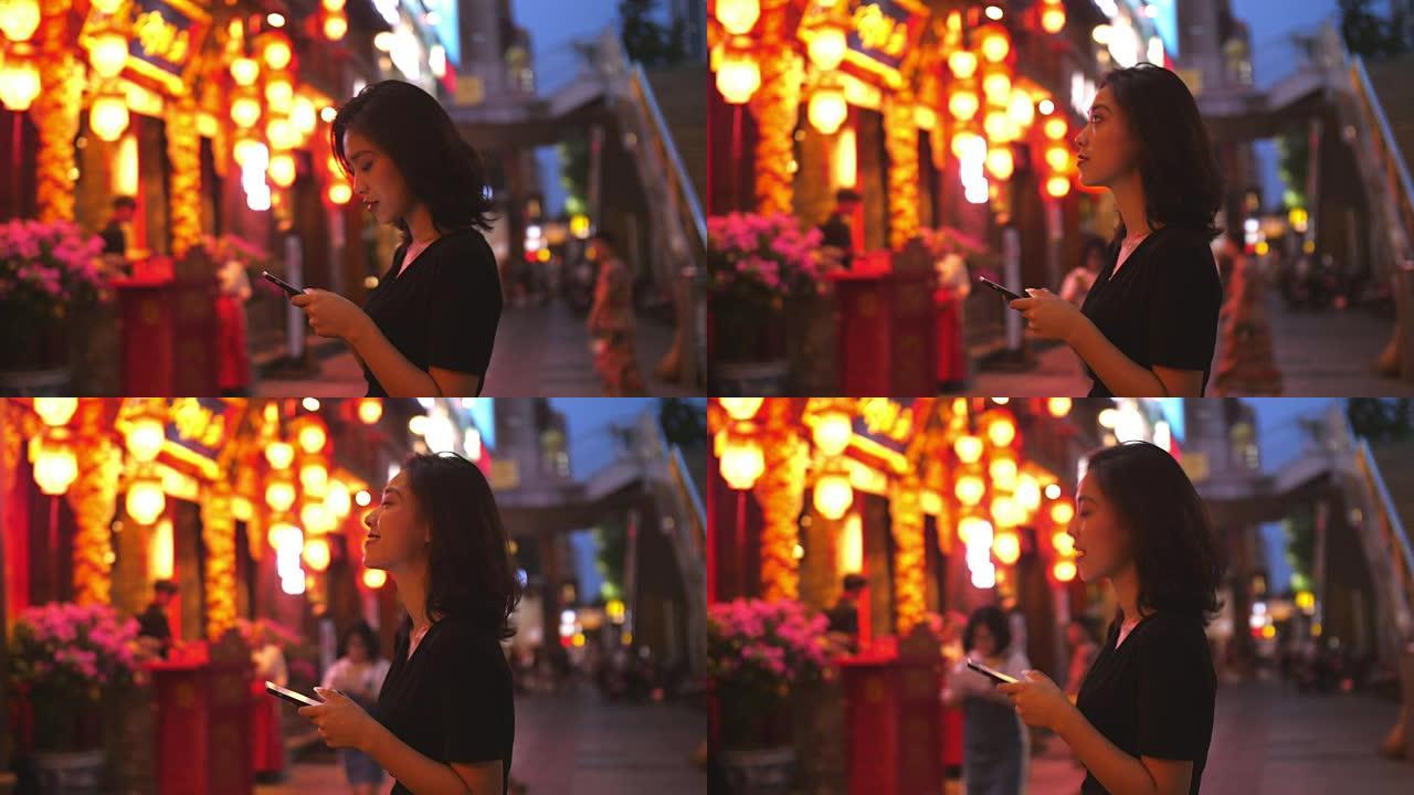 年轻的中国妇女在街上使用电话