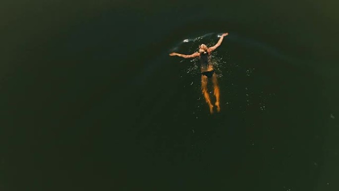 女人在湖里游泳。夏季活动