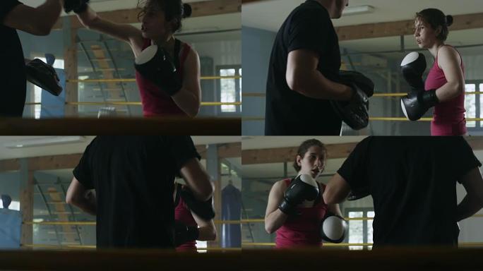 在拳击馆与教练一起工作的女拳击手