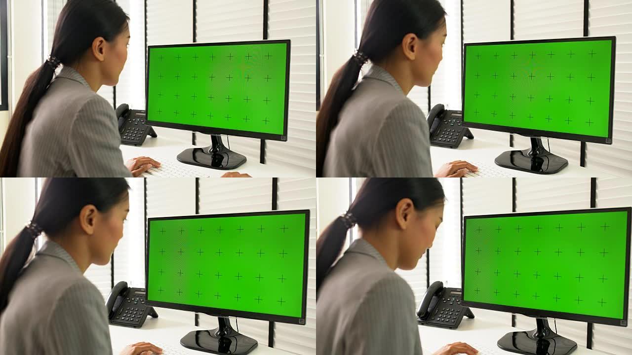 女商人使用带有绿屏的计算机