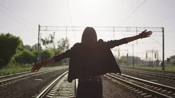 年轻女子在铁路上走开。摇滚风格。