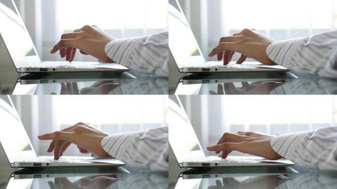 Dolly Shot: 女人的手在笔记本电脑键盘上打字，特写