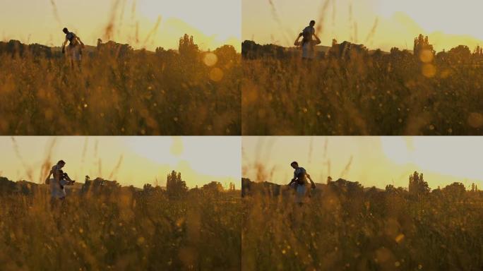 SLO MO父亲在日落时将儿子带到草地上