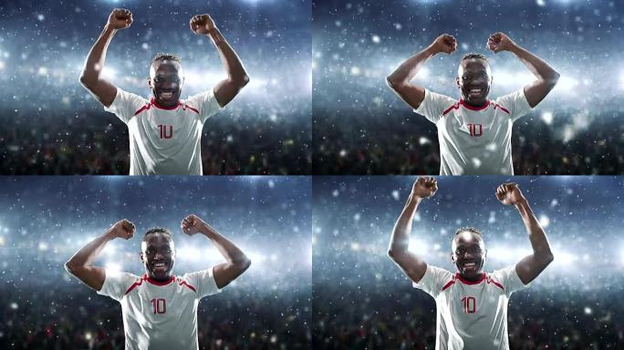 足球运动员庆祝胜利，并在下雪时在专业体育场高兴地举起手臂