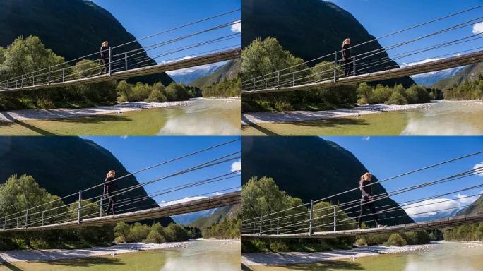 年轻女子越过山涧上的木制吊桥