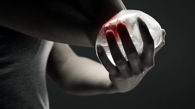 一个女人把冰块放在疼痛的肘部。