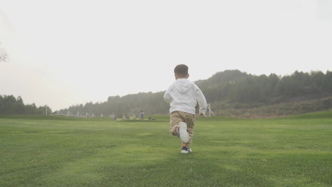 小孩草地奔跑美好童年小孩奔跑背影健康成长
