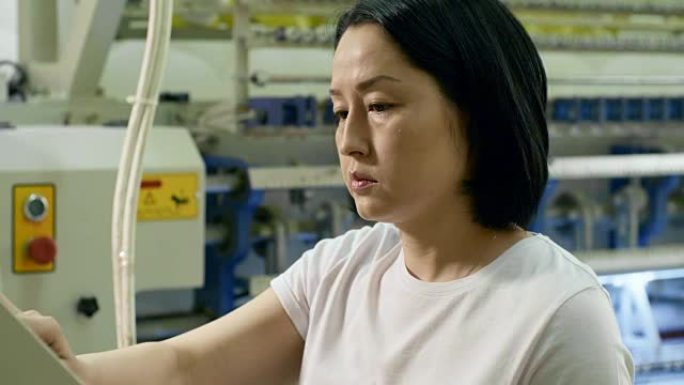 操作纺织机的亚洲女技师