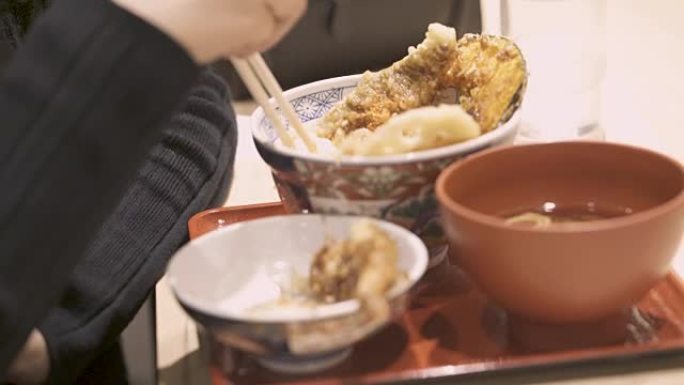 女人用筷子吃日本天妇罗食物
