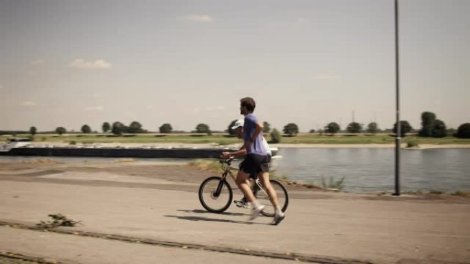 城市跑步者骑车陪练复古怀旧色调河边航运