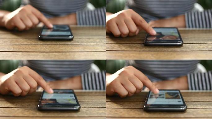 在木桌上使用智能手机的特写年轻沃莫安，4K (UHD)