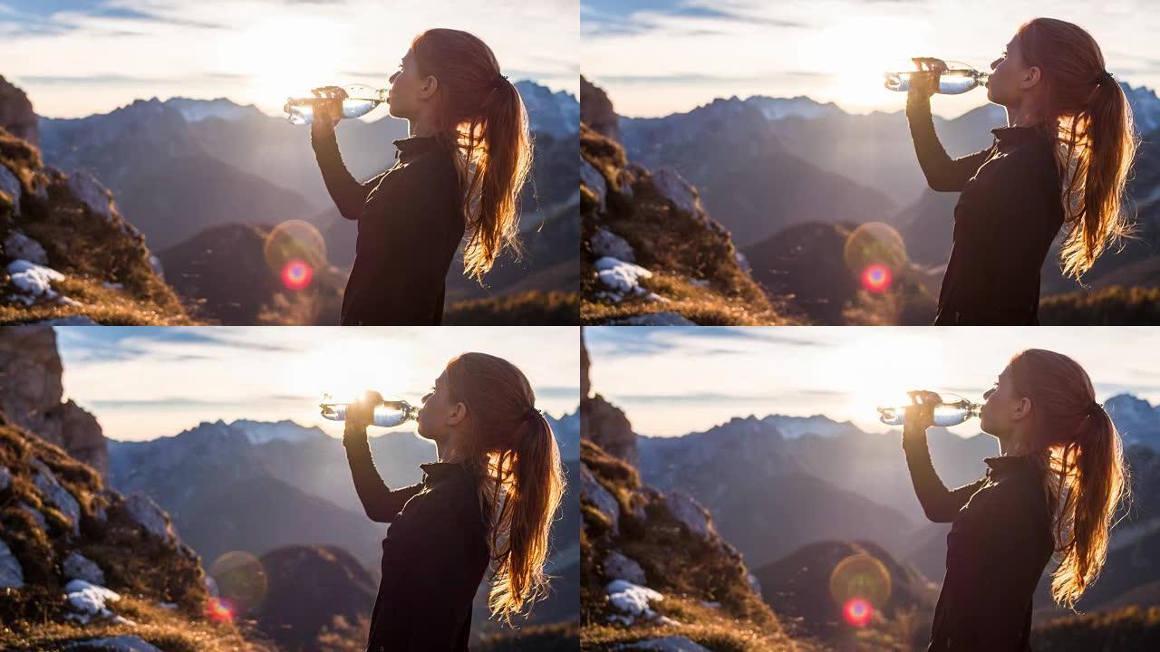 年轻女子在山顶喝水