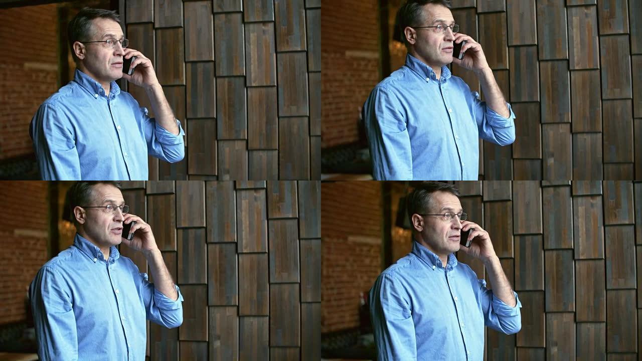 戴眼镜的成熟男人在电话上聊天