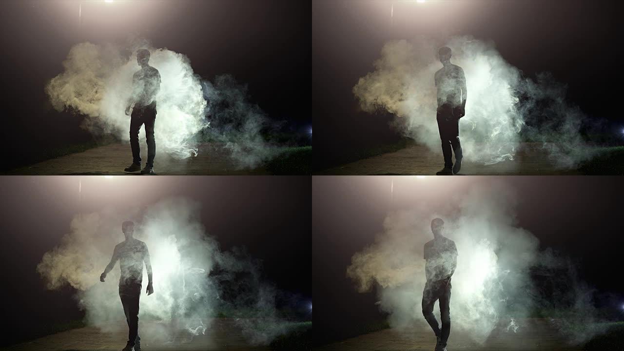那个男人站在黑暗背景上的烟雾中，慢动作