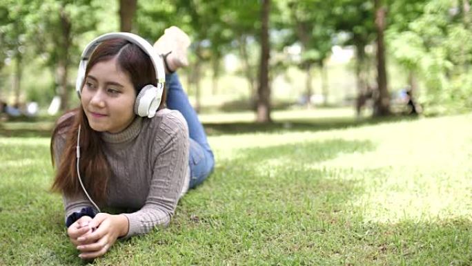 戴着耳机的女人在公园听音乐