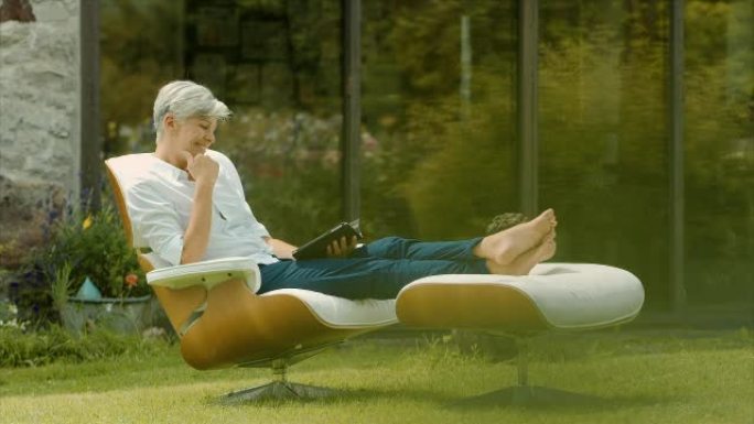 一位老妇人坐在花园里看书