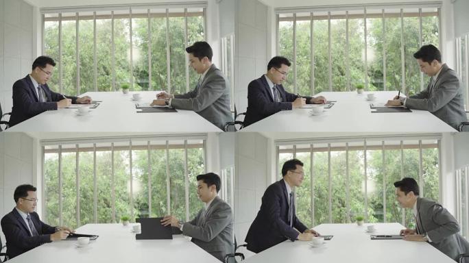 慢动作-求职会议后握手达成协议。两位亚洲自信的商人在办公室开会时握手，成功，交易，问候和合作伙伴概念