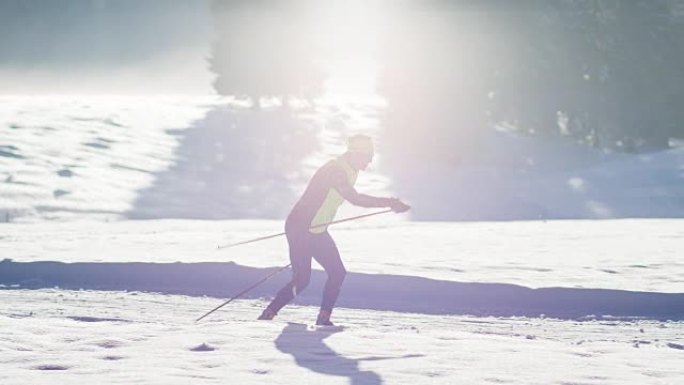 越野滑雪者在冬季景观中的滑雪道上滑行