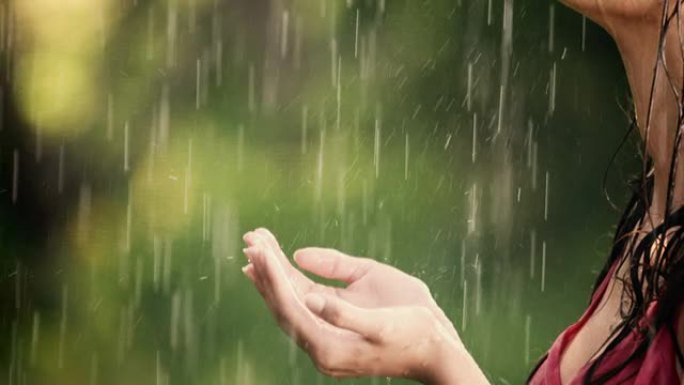 女人在夏雨中享受并握住她的手