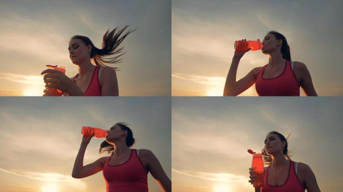 苗条好看的女人在新鲜空气中奔跑，从瓶子里喝水