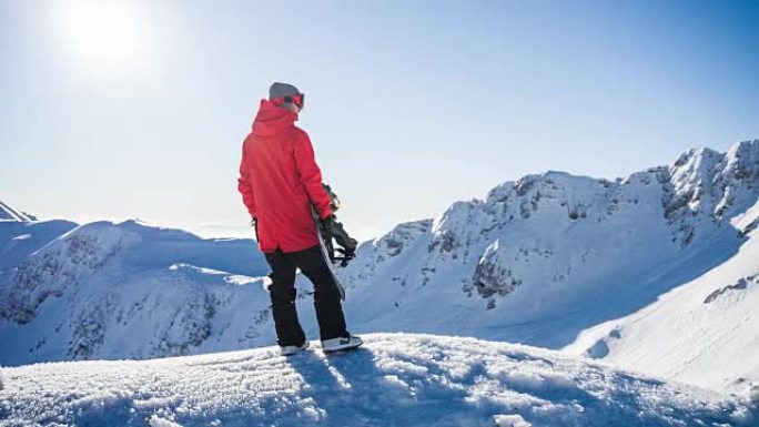 白雪皑皑的山顶上的滑雪者准备撞上山坡