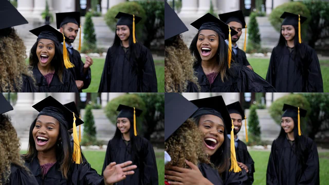 兴奋的年轻大学毕业生拥抱她的朋友
