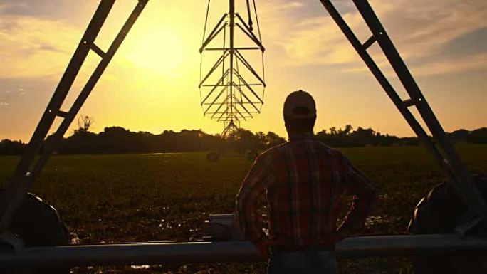 DS农民在日落时看着农业洒水器