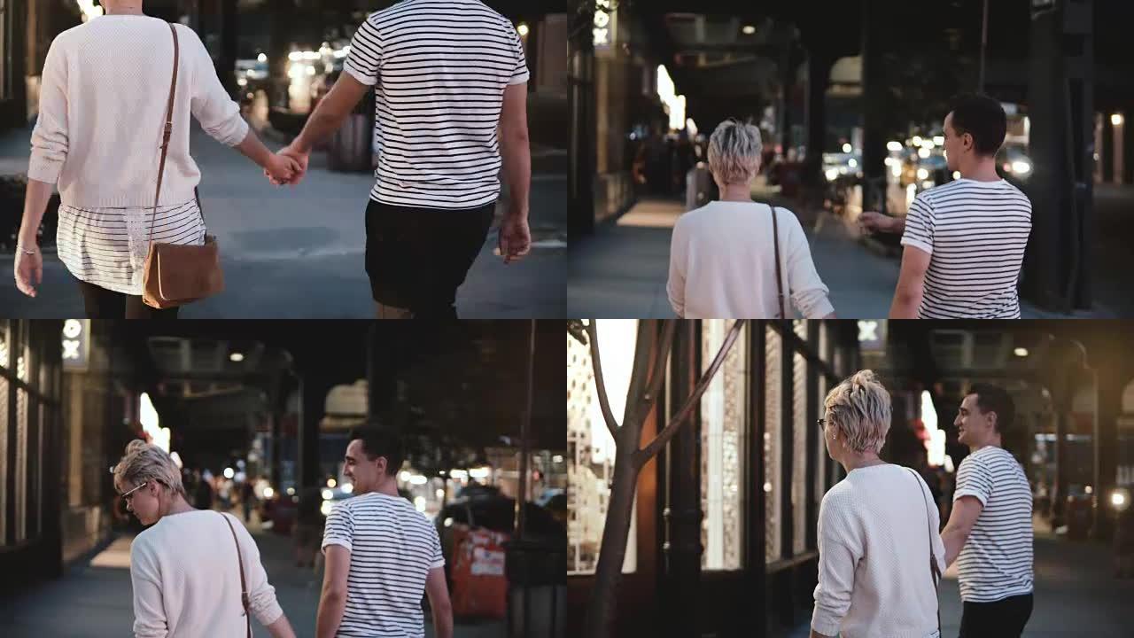 快乐浪漫的情侣手牵手散步，沿着纽约苏豪街晚上左转，享受晚上的城市约会