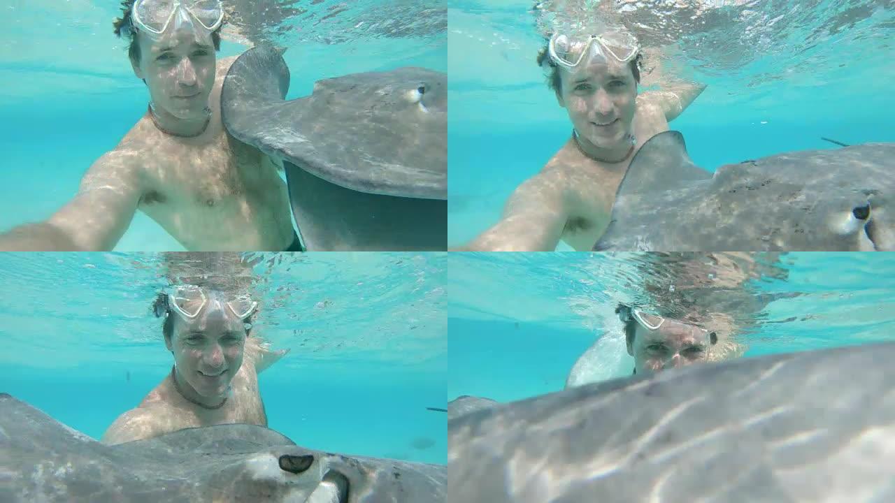 水下: 微笑的男人在海洋中潜水时用黄貂鱼自拍。