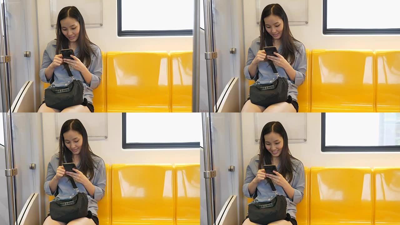 年轻的亚洲妇女在旅客列车上发短信