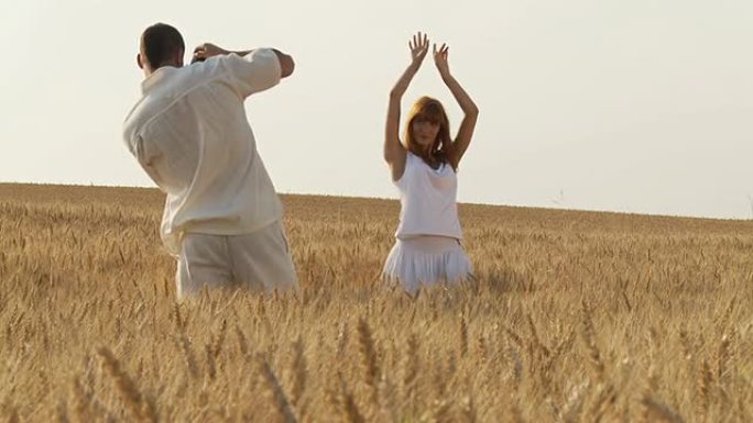 高清：一名年轻男子在拍摄一名身穿小麦的女子的照片