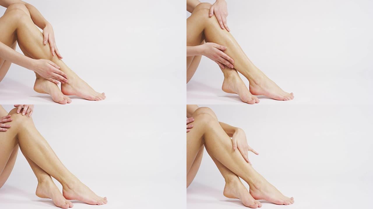 在腿上涂霜的女人女人涂抹保湿霜护肤化妆品