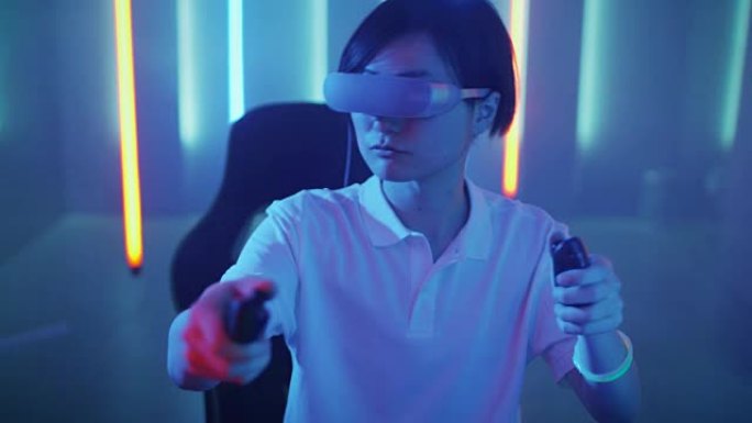 戴着虚拟现实耳机的东亚职业玩家在在线视频游戏中打手势。房间里很酷的复古霓虹灯颜色。