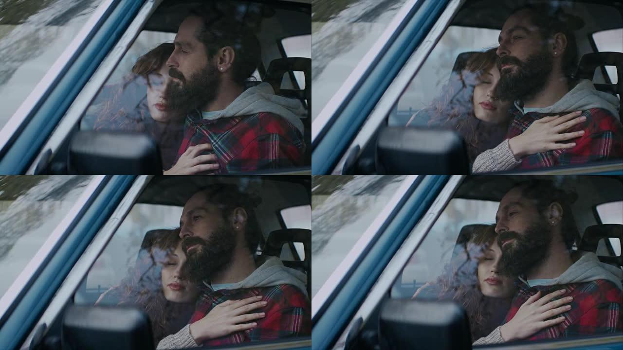 一对年轻夫妇坐在一辆车里，拥抱着，看着前面的窗户