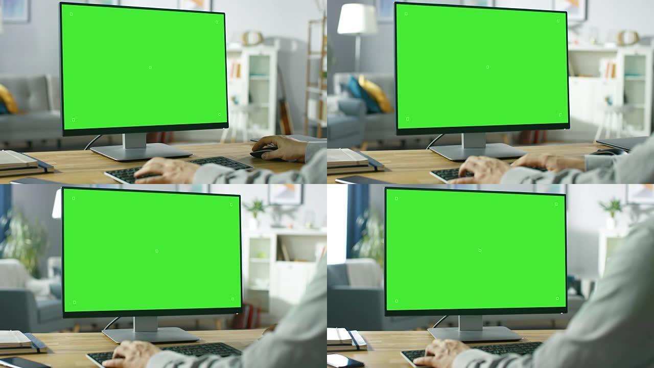 在专业自由职业者的肩膀上，在家中使用绿色模型屏幕个人计算机。男人的手打字，他在舒适的客厅中浏览互联网