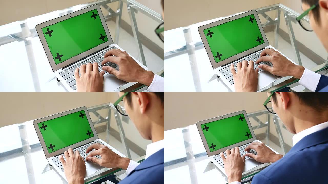 商人在带有绿屏的笔记本电脑上使用