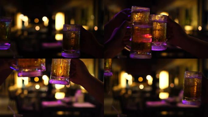 慢动作FHD镜头特写烤酒和碰杯啤酒，在酒吧和餐厅一起欢呼，放松和喝酒的概念
