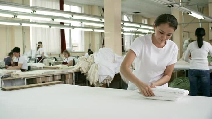 纺织厂妇女折叠白色织物