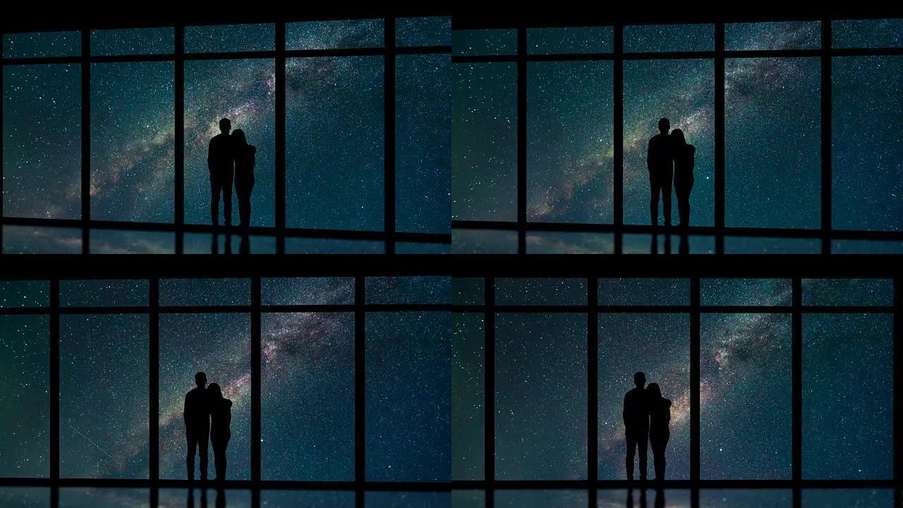 男人和女人站在星空背景上的窗户附近。时间流逝