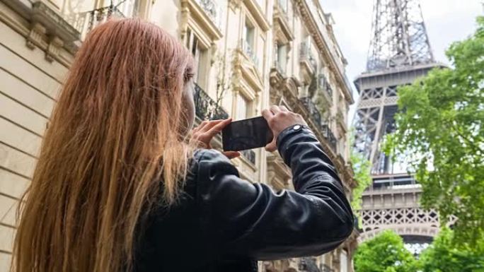 巴黎的女人用手机拍摄埃菲尔铁塔