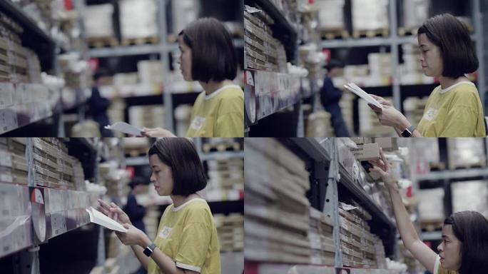 年轻女子正在检查她的名单。把它们放在仓库的手推车上