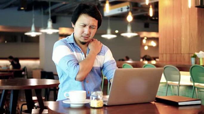4k镜头亚洲商人穿着休闲西装的场景在笔记本电脑前工作并遭受肩颈疼痛的折磨-工作空间，商业健康和办公室