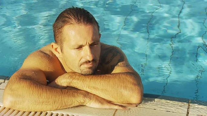 高清：男子在泳池边放松